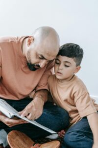A father and son engaged in reading together, enhancing family bonding.